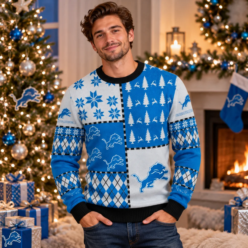 Man in a Detroit Lions patchwork ugly Christmas sweater with snowflakes, trees, and lion logos by a fireplace